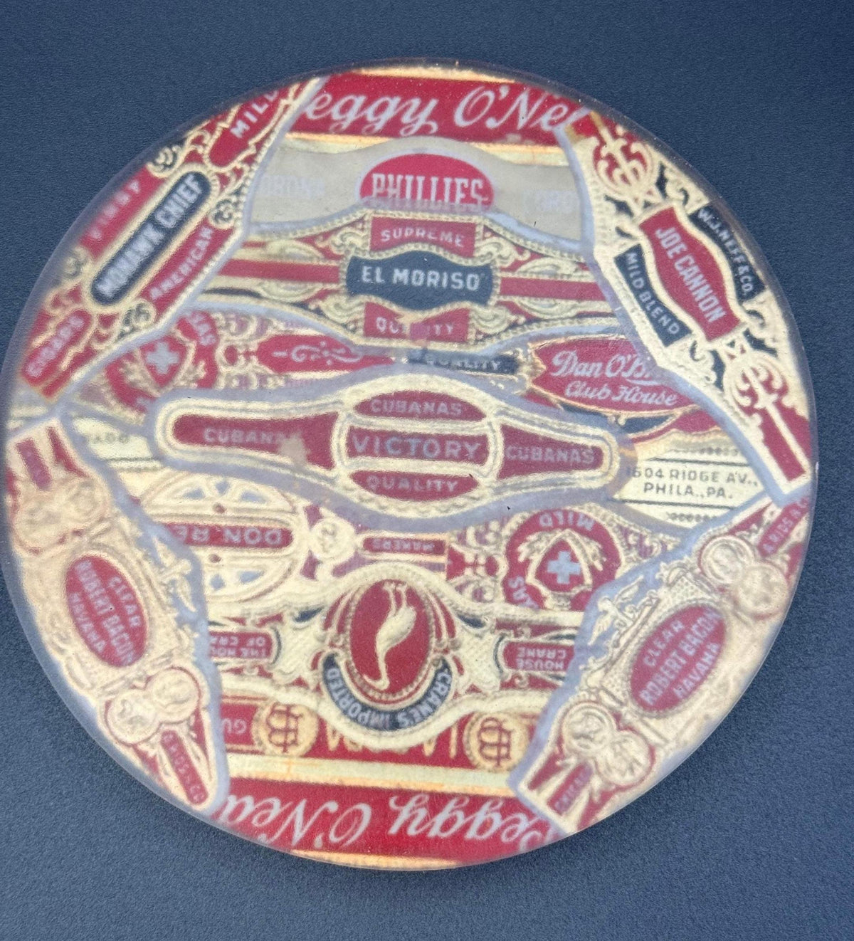 May include: Circular vintage cigar label with red, gold, and white text and designs. The label features text such as "Peggy O'Neil," "Phillies," "Victory Cubanas," and "Joe Cannon." The label has a clear, protective covering.vintage cigar, cigar coasters, cigar box art, antique cigar, whiskey coaster, bar drink coaster, cigar lounge decor, man cave decor, epoxy coasters, wood coasters, cigar gift, retro bar decor, classic bar decor